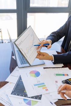 Business professionals discussing financial graphs and charts in an office setting.