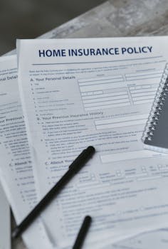 Flatlay image featuring a home insurance policy form and a notebook, shot from above.