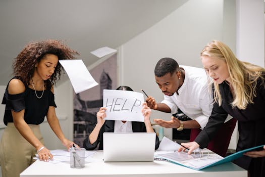 Team of stressed colleagues in an office dealing with paperwork chaos, asking for help.